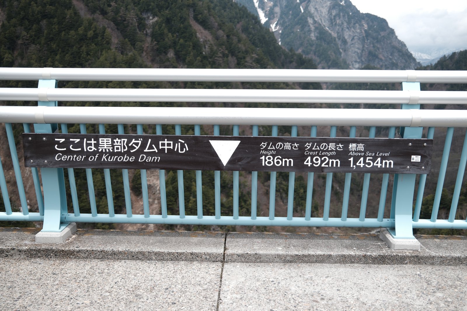 ป้ายระบุข้อมูลของเขื่อนคุโรเบะ — Height 186m, Crest Length 492m, Above Sea Level 1454m — แสดงเป็นภาษาญี่ปุ่นและอังกฤษ