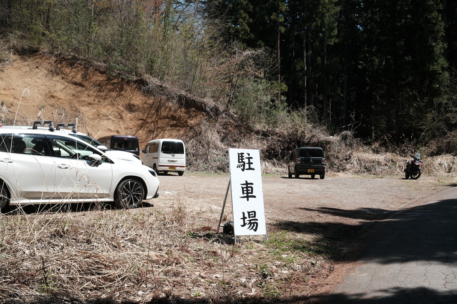 ลานจอดรถบริเวณซากุระบันโดโคโระ มีรถจอดและป้าย 駐車場
