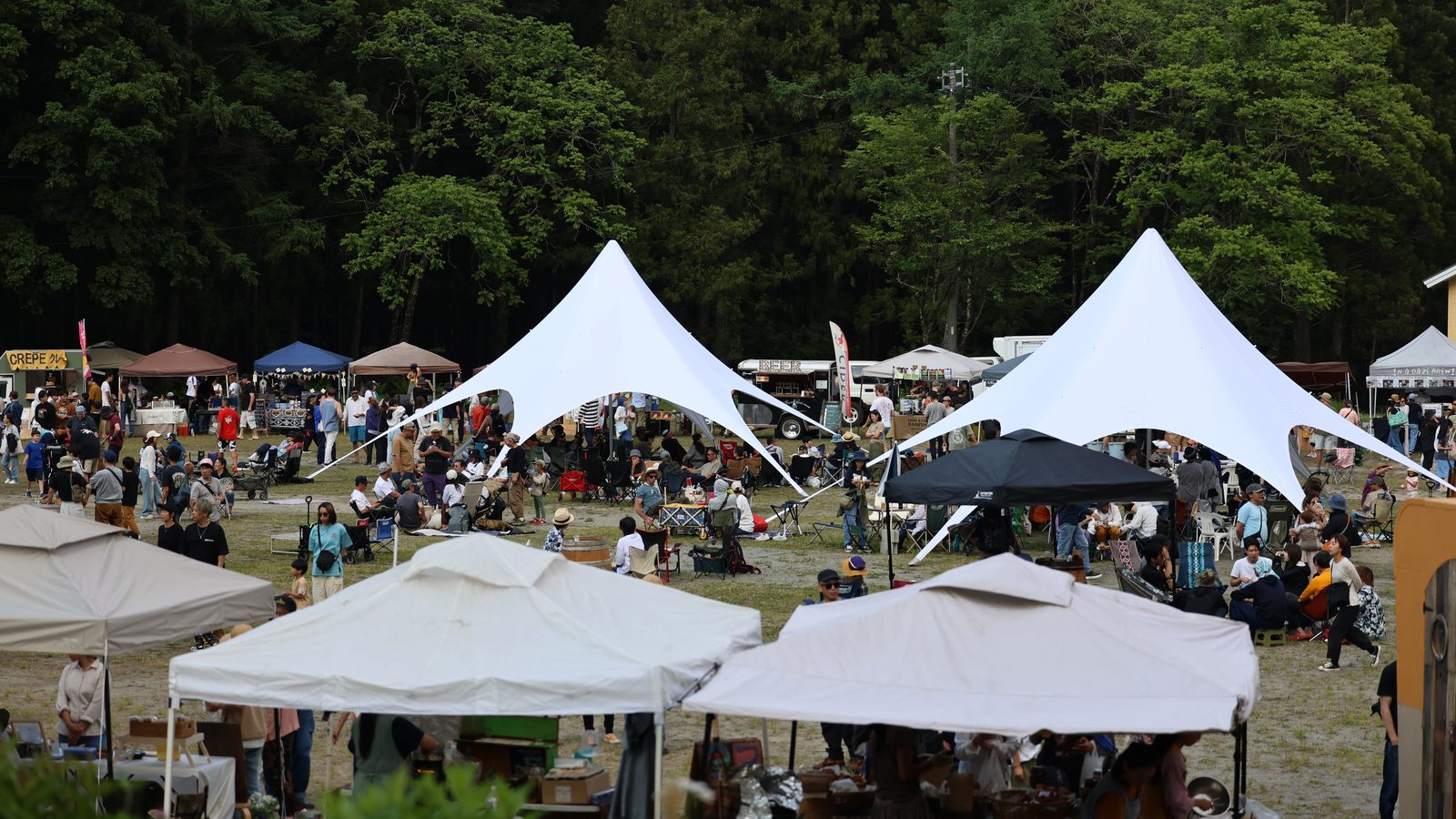 บรรยากาศงาน Craft Beer Marche in Hakuba เต็มลานกว้าง เต็นท์สีขาว ผู้คน และป่าเขียวเป็นฉากหลัง