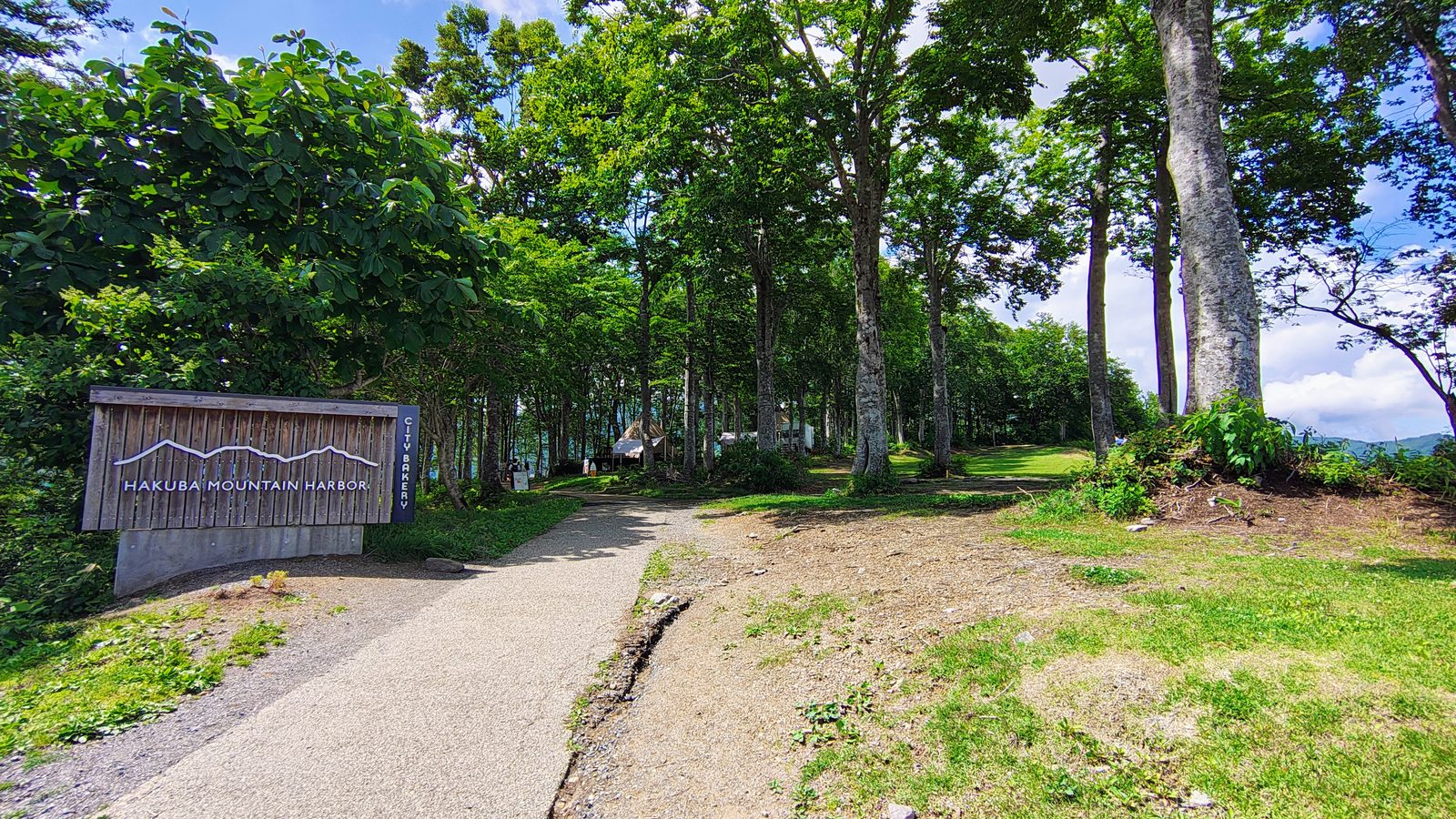 ป้ายทางเข้า HAKUBA MOUNTAIN HARBOR ท่ามกลางป่าบีช