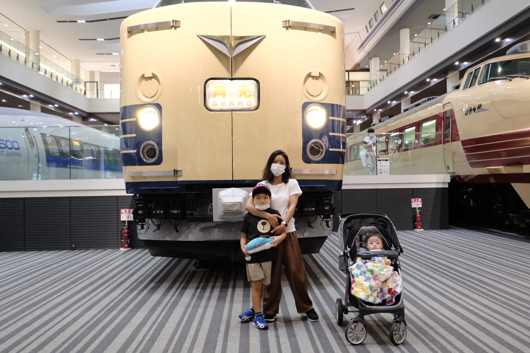 ครอบครัวถ่ายรูปกับรถไฟด่วนเกกโก สีครีมน้ำเงิน