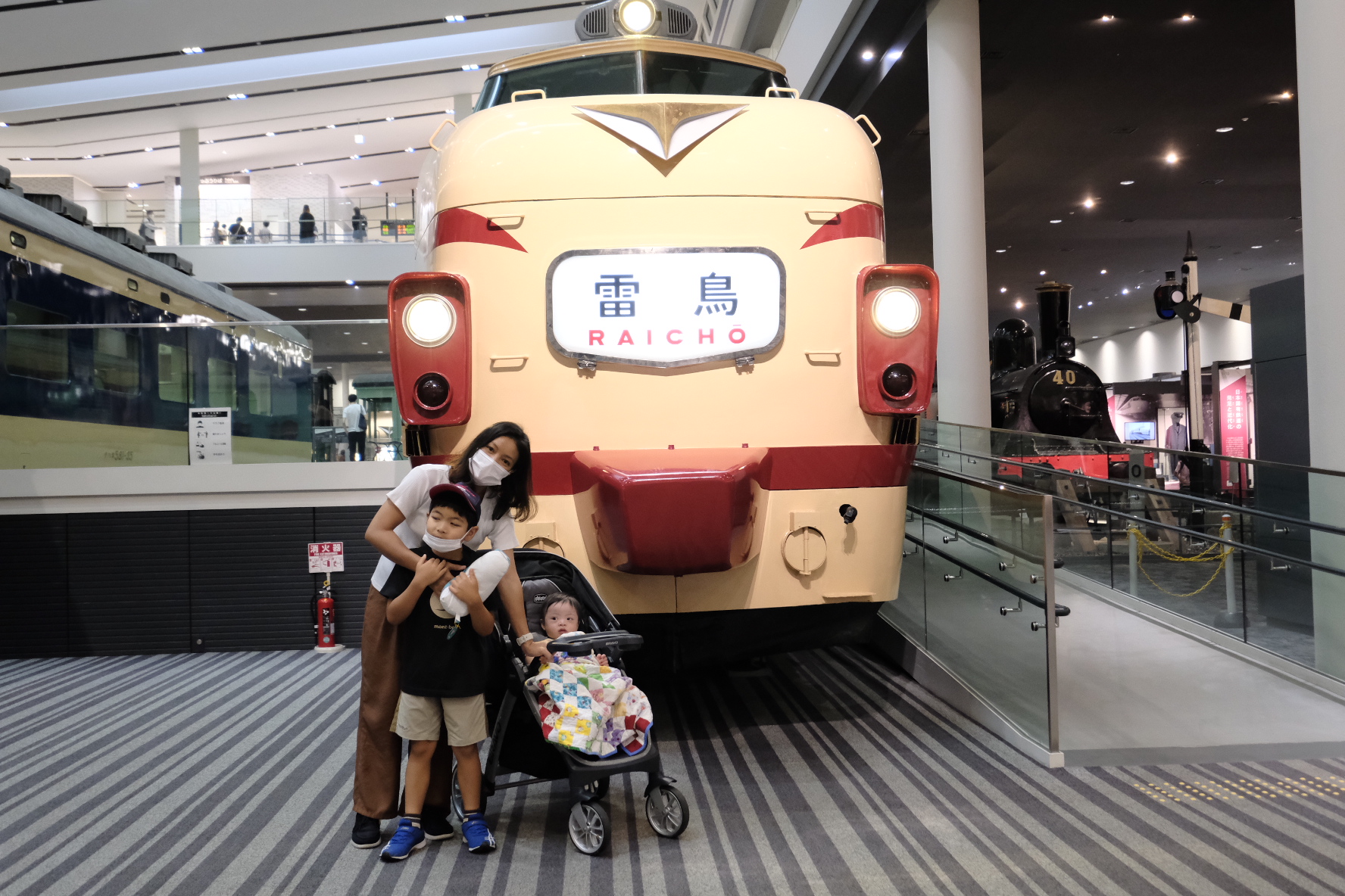 ครอบครัวถ่ายรูปกับรถด่วนไรโช สีครีมแดง