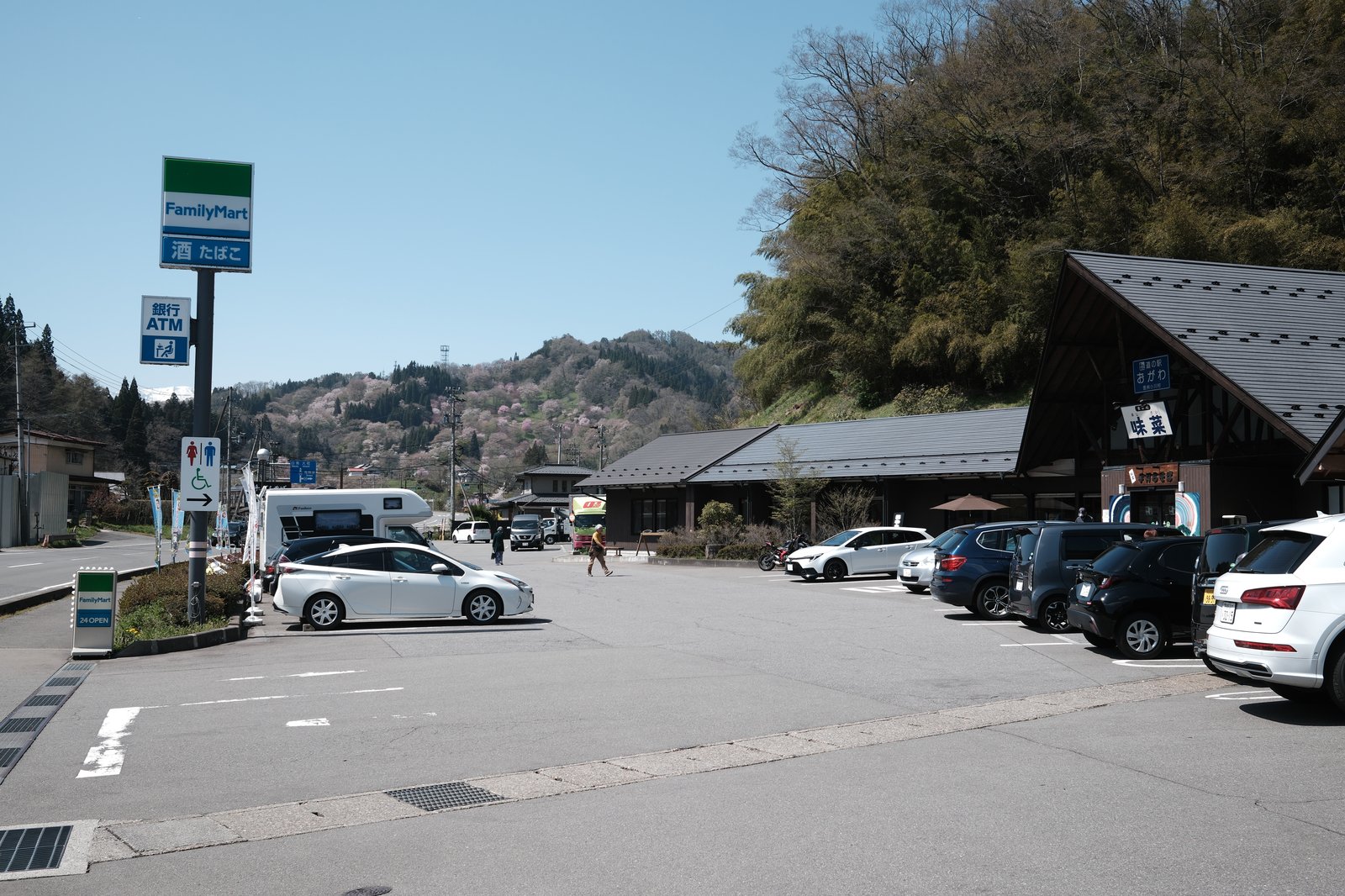 ลานจอดรถของ Sansan Ichiba พร้อมร้านสะดวกซื้อ FamilyMart และอาคารร้านโซบะ
